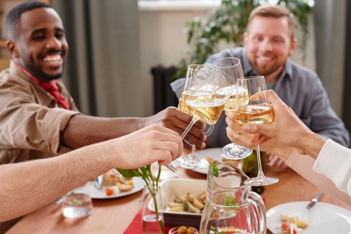 Men raising glasses together at a table